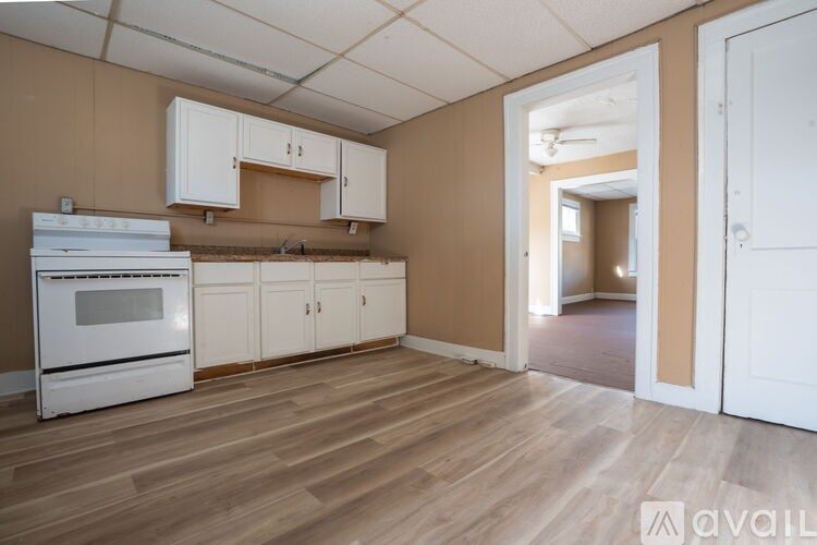 A kitchen with white appliances and cabinets is available for rent.