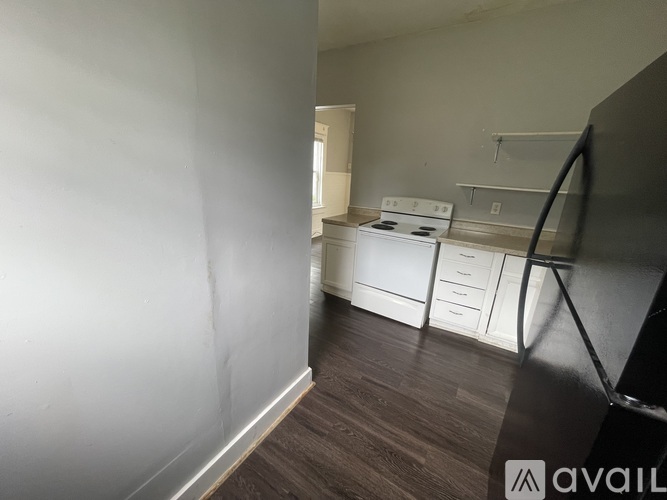 A kitchen area with a stove and drawers is visible through a doorway.