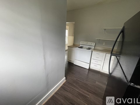 A kitchen area with a stove and drawers is visible through a doorway.