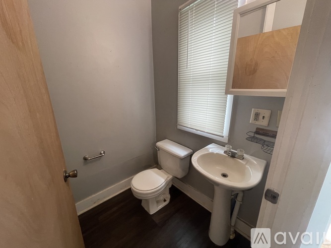 A white toilet sits next to a white sink in a small bathroom.