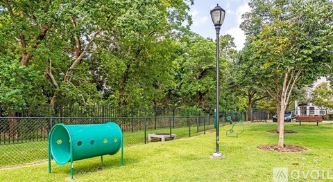 A playground with a green slide and a lamp post.