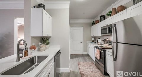 A kitchen with white cabinets and a stainless steel refrigerator.