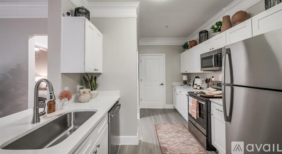 A kitchen with white cabinets and a stainless steel refrigerator.