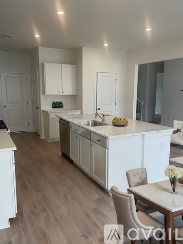A kitchen with white cabinets and a wooden floor.