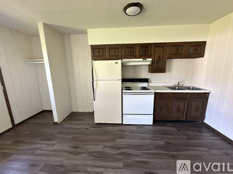 A kitchen with a white fridge, stove, and sink.