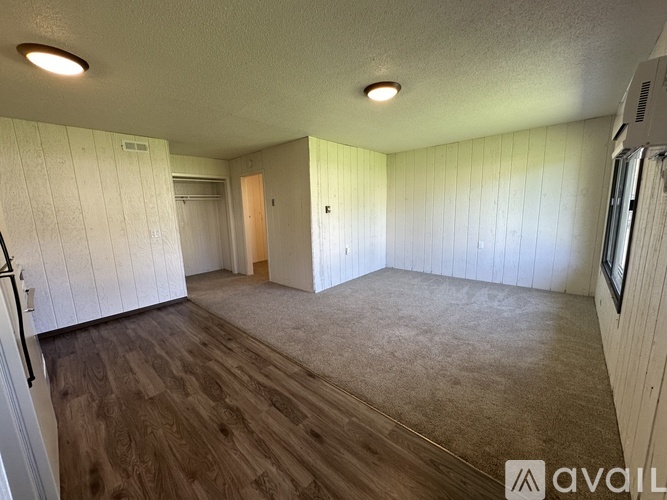 A room with wooden flooring and white walls.