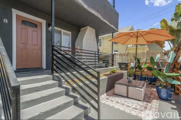 A small balcony with a brown door and a metal railing.