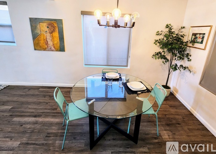 A dining room with a glass table and chairs.