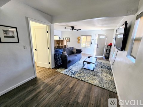 A living room with a blue couch and a rug.