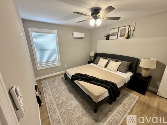 A bedroom with a bed, a ceiling fan, and a rug.