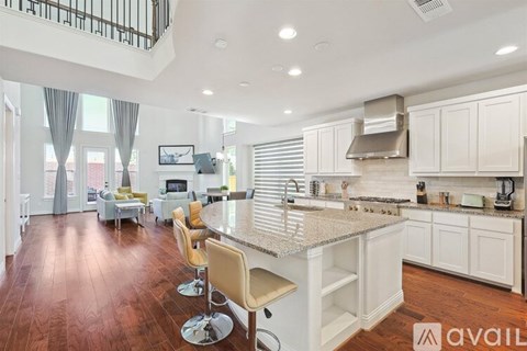 A kitchen with white cabinets and a wooden floor.