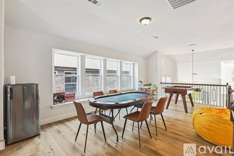 A room with a pool table and chairs.