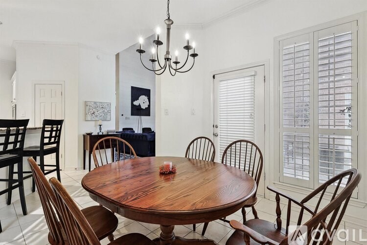 A dining room with a wooden table and chairs.
