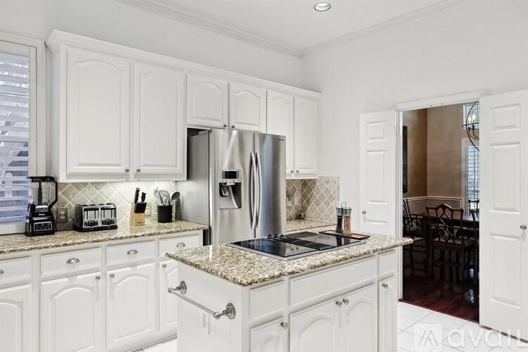 A kitchen with white cabinets and a granite countertop.