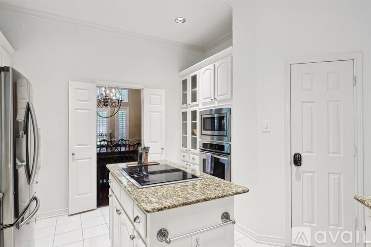 A kitchen with granite countertops and white cabinets.