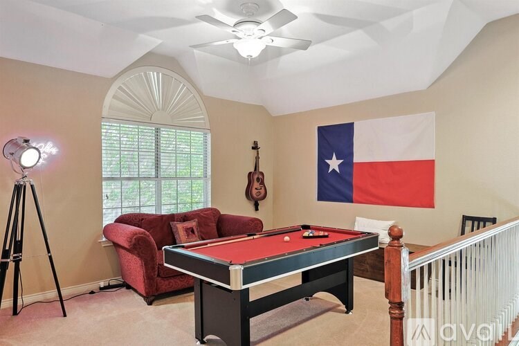 A room with a pool table and a Texas flag hanging on the wall.