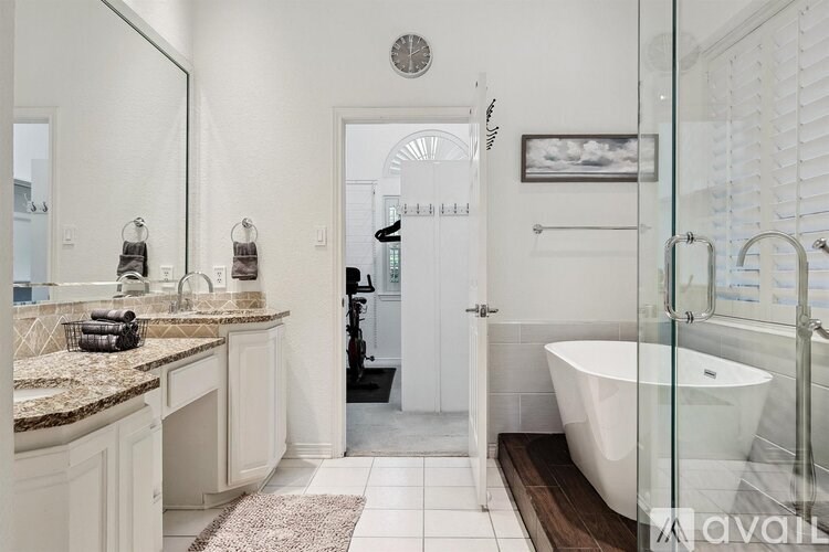 A bathroom with a white tub and a glass shower door.