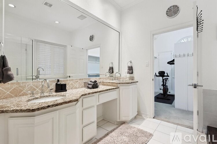 A bathroom with a large mirror, two sinks, and a white cabinet.