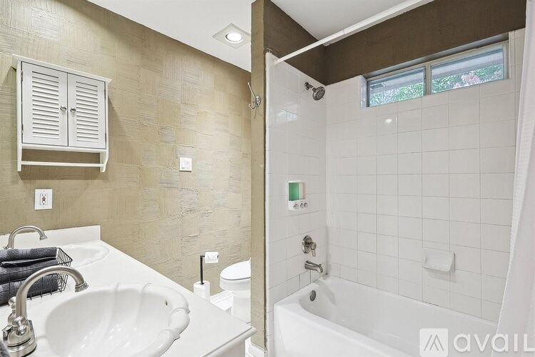 A bathroom with a white sink and a white bathtub.