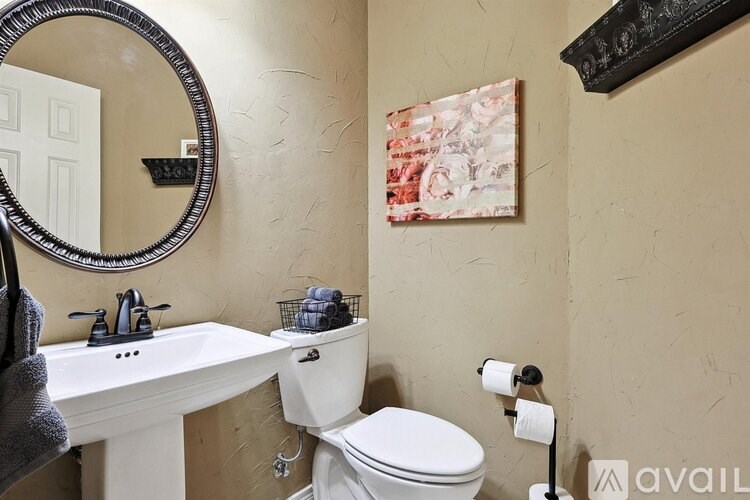 A bathroom with a toilet, sink, and a mirror.