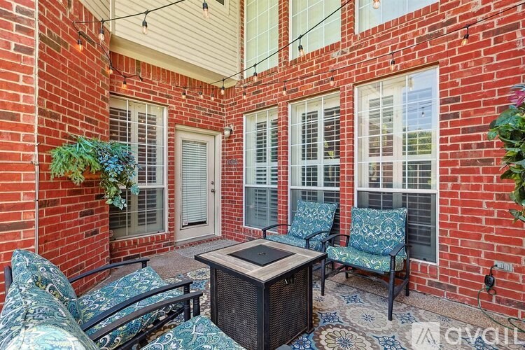 A patio with a table and chairs is surrounded by a brick wall.