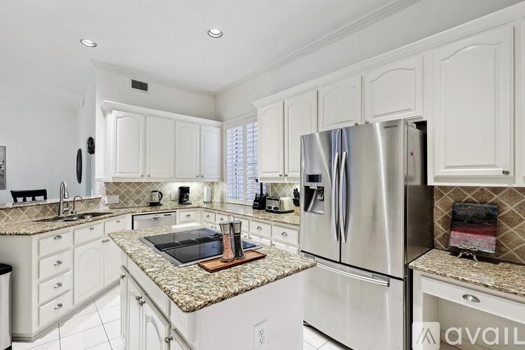 A kitchen with white cabinets and granite countertops.