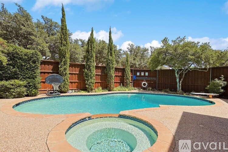 A swimming pool surrounded by a wooden fence and trees.