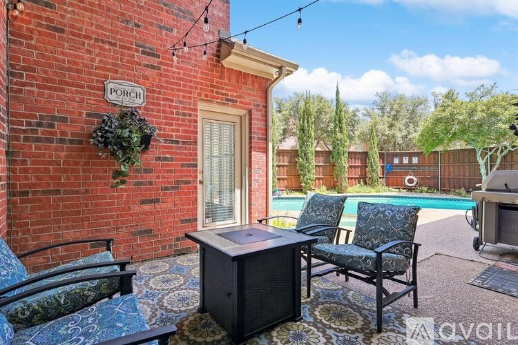 A patio area with a brick wall and a pool in the background.