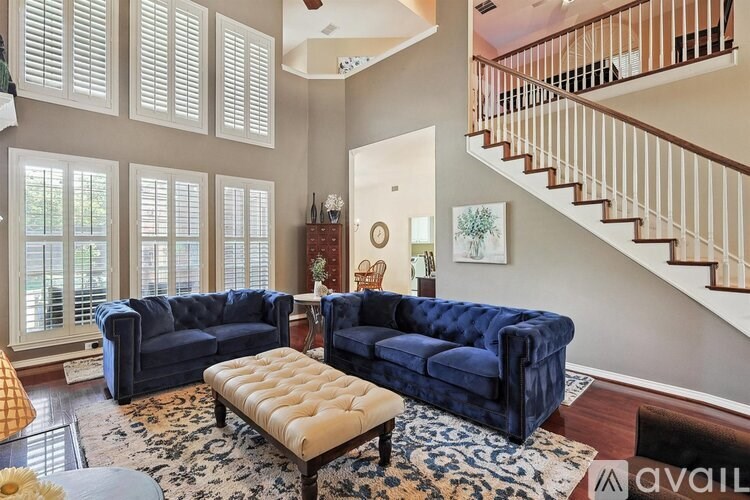 A living room with a blue couch and a rug.