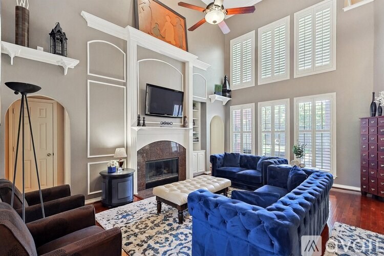 A living room with a fireplace and a blue couch.
