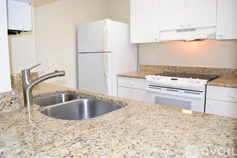 A kitchen with granite countertops and a stainless steel sink.