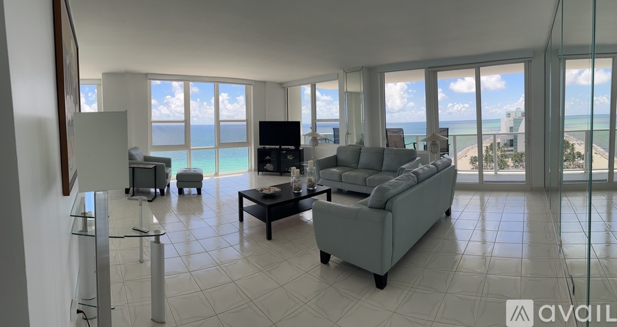 A dining room with a table set for six with a view of the ocean.
