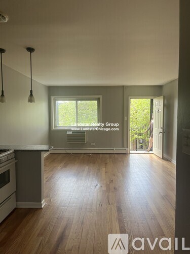 A kitchen with wooden floors and a window that says Landstar Realty Group.