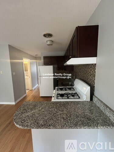 A kitchen with a granite countertop and a stove top oven.