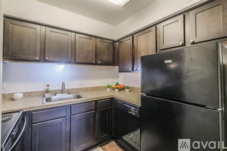 A kitchen with black cabinets and a black refrigerator.