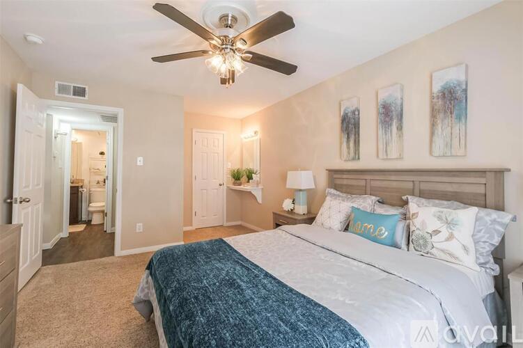 A bedroom with a large bed and a ceiling fan.