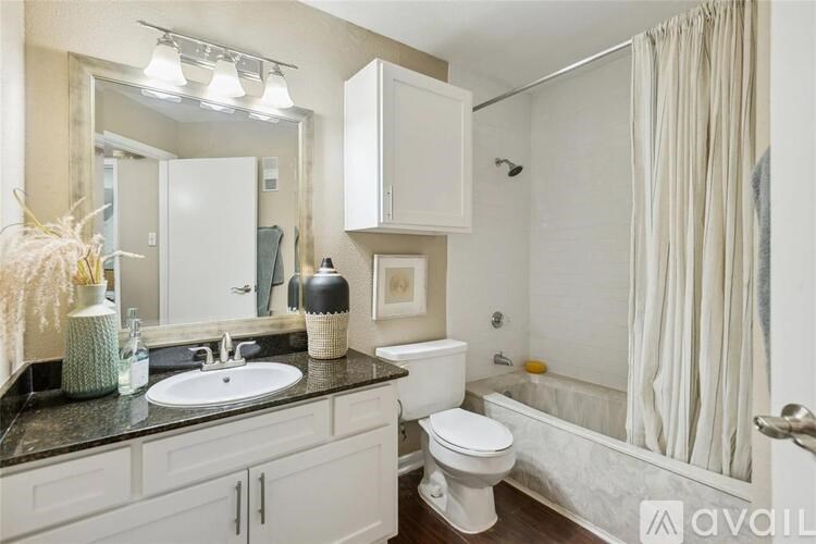 A bathroom with a white toilet, sink, and shower.