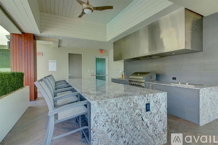 A kitchen with a marble countertop and a ceiling fan.