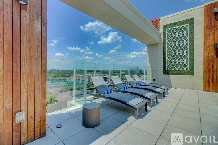 A balcony with a row of chairs and a table.