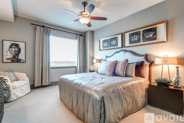 A well-lit bedroom with a large bed and a ceiling fan.