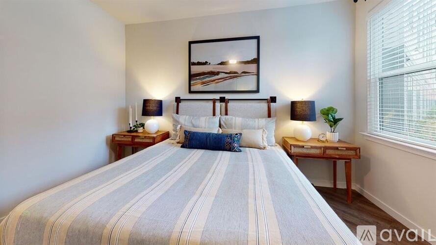 A bedroom with a large bed and a painting above it.