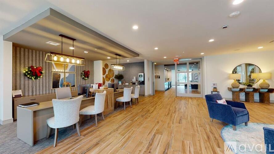 A spacious office with a long wooden floor and white chairs.