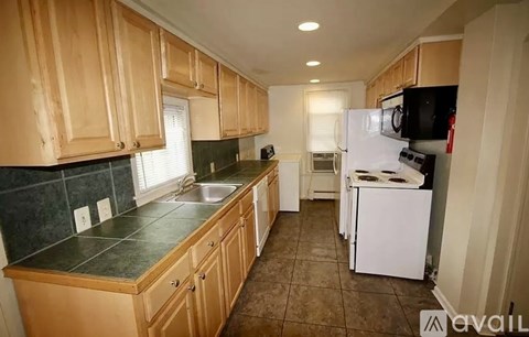 A kitchen with wooden cabinets and a white refrigerator.