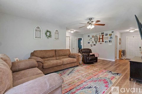 A living room with a brown couch and a rug.