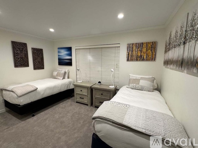 A bedroom with two beds and a nightstand.