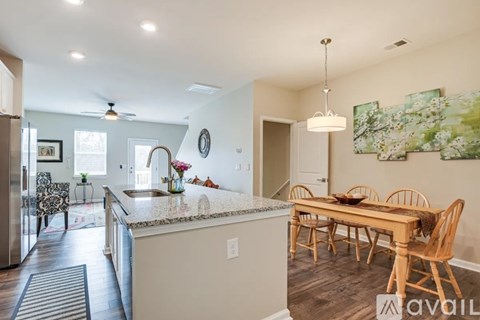 A kitchen with a dining table and chairs.