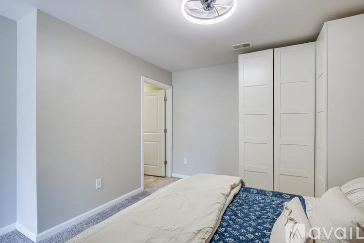 A bedroom with a bed and a ceiling fan.