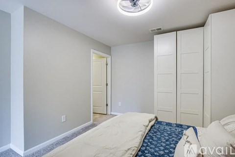 A bedroom with a bed and a ceiling fan.