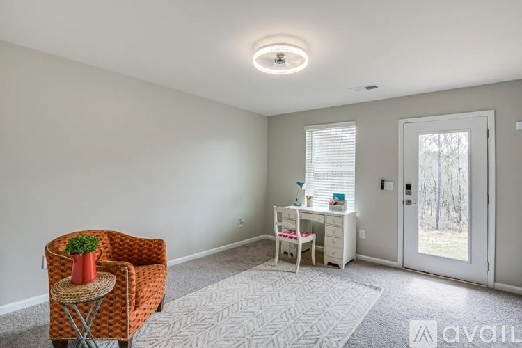 A room with a chair, a small table, and a carpet.