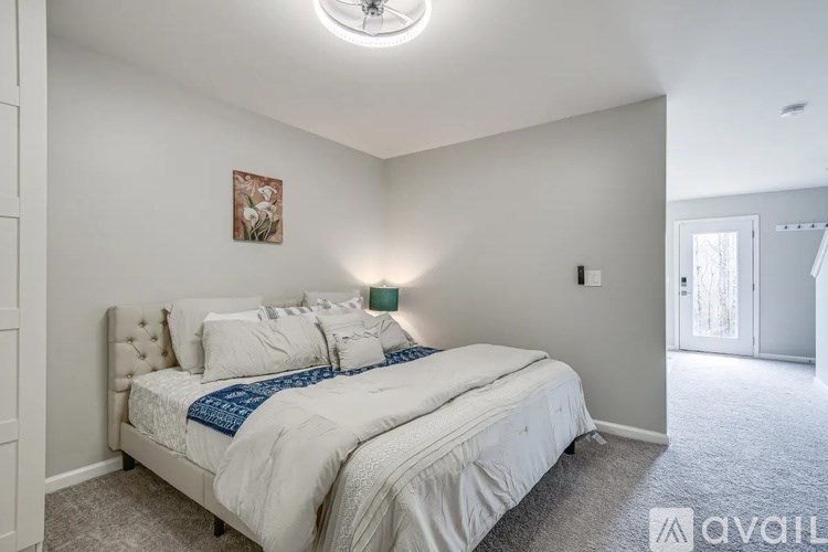 A bedroom with a large bed and a painting on the wall.
